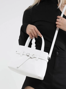 Minimalist white square handbag with knotted strap detail shown on a model