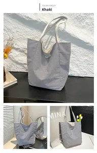 Detail view of khaki striped canvas tote bag with long handles and embroidery detail
