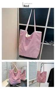 Detailed view of red and white striped canvas tote bag with textured embroidery and long handles