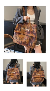 Close-up of camouflage canvas backpack featuring orange abstract print and aaaang embroidery