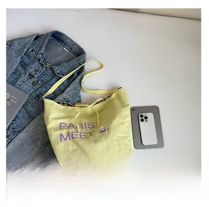 Detailed size comparison of yellow tote bag with a smartphone and tablet for scale