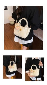 Details der cremefarbenen Eimer-Tasche mit Krokodil-Prägung und kleinem Bärenanhänger