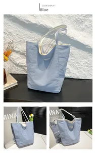 Close-up of blue and white striped canvas tote bag with textured embroidery and durable straps
