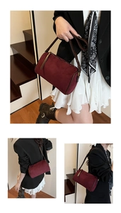 Close-up of burgundy suede boston bag featuring sleek brown strap and metallic zipper