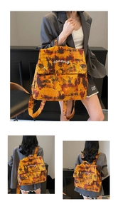 Close-up of orange camouflage backpack with white aaaang lettering and flap pocket detail