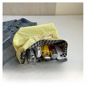 Detail showing the large capacity of the yellow canvas tote bag with daily items