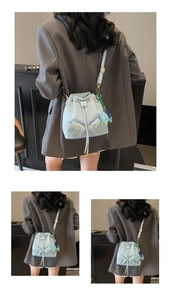 Detail view of light blue leather bucket bag with drawstring closure and elephant charm