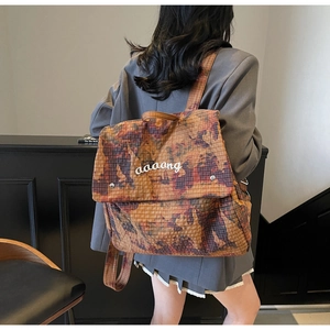 Detail of artistic camouflage backpack showing textured fabric and aaaang brand printing