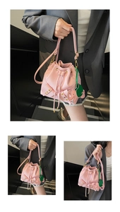 Detail view of pink lychee leather bucket bag with cute elephant charm and gold rivets