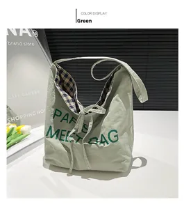 Detail of green tote bag featuring Paris Meet Bag print, bow tie and blue plaid lining