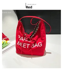 Detail of red fabric tote bag with white Paris lettering and classic checkered lining