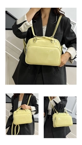 Detail of a shiny pale yellow oil wax leather backpack showing functional front zip pocket