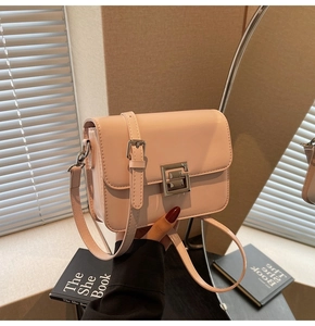Close-up of pink glossy leather crossbody bag featuring silver geometric metal clasp and strap