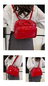 Detail of red patent leather mini backpack featuring shiny finish and silver zippers