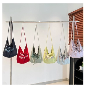 Detailed collection of colorful canvas tote bags with Paris embroidery hanging on a rack