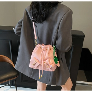 Pink lychee grain leather bucket bag with drawstring closure and cute elephant charm detail