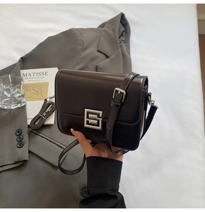 Detail view of the vintage chocolate brown leather bag with a silver S-buckle and strap