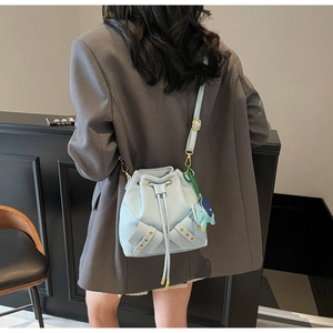 Detail of light blue lychee pattern bucket bag with drawstring and elephant charm