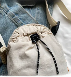 Detail of drawstring closure with adjustable toggles on lightweight nylon crossbody bag
