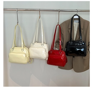 Four colors of glossy patent leather shoulder bags hanging with front zip pockets