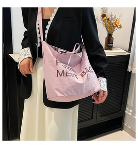 Detail of pink embroidered tote bag with Paris lettering shown in lifestyle context