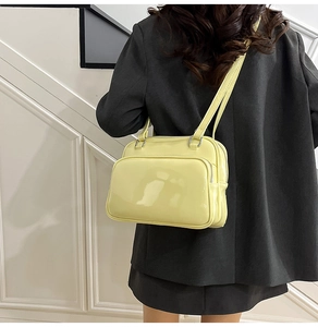 Chic light yellow oil wax leather handbag shown as a crossbody on a black blazer
