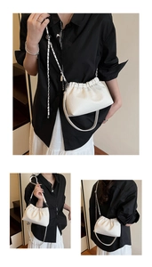 Detail view of white ruched cloud bag with lychee texture and adjustable chain strap