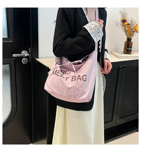 Detail of pink fabric tote bag with PARIS MEET BAG text styled with casual outfit