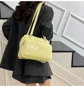 Detail of glossy yellow oil-waxed leather backpack with silver zippers and dual straps