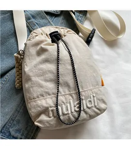 Detail of nylon drawstring crossbody bag with embroidered logo and checkered drawcord