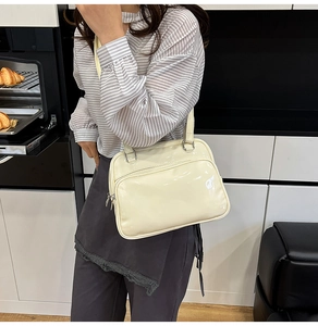 Chic beige oil-wax leather handbag shown in a lifestyle kitchen setting with model