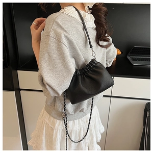Close-up of black lychee grain leather pleated cloud bag with silver metal chain strap