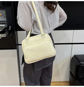 Detail view of cream oil wax leather shoulder bag showing glossy finish and silver rings
