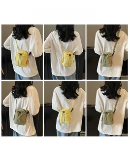 Detail view of colorful nylon drawstring crossbody bags showing back carrying effect