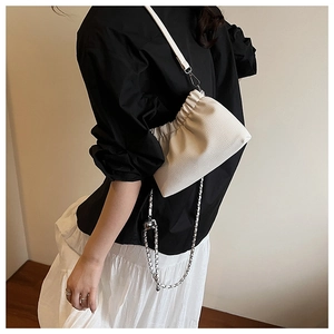 Detail view of white ruched cloud bag with fine pebble texture and silver chain strap