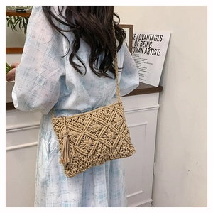 Detail of a beige handmade crochet shoulder bag featuring fringe and geometric textures