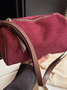 Minimalist burgundy suede pillow bag with brown leather trim and metal zipper for women