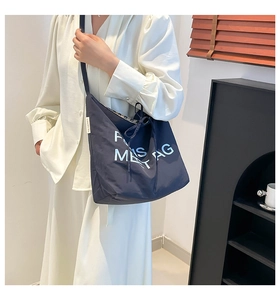 Close-up of navy canvas tote bag featuring white Paris embroidery and drawstring closure