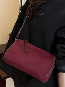 Maillard burgundy suede pillow bag with minimalist cylindrical design and thin shoulder strap