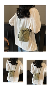 Rear view of model wearing military green drawstring canvas crossbody bag for daily use