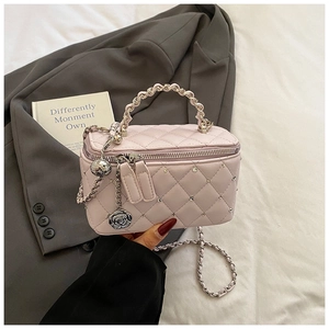 Close-up of pink quilted vanity bag with crystal studs and rose metal charm detail
