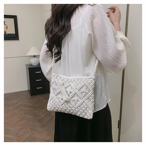 Detail of white handmade macrame crossbody bag with boho tassels and diamond woven pattern