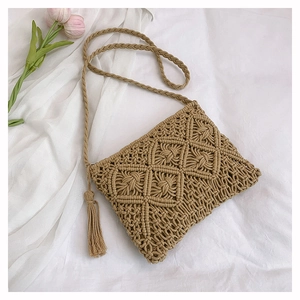 Macro detail of hand-woven diamond pattern and tassel on a khaki bohemian crossbody bag