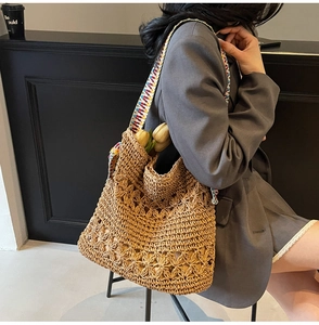 Dettaglio della borsa in paglia all'uncinetto con tracolla etnica colorata e tulipano