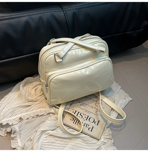 Detail of a creamy white glossy oil-wax leather backpack with multi-pocket design