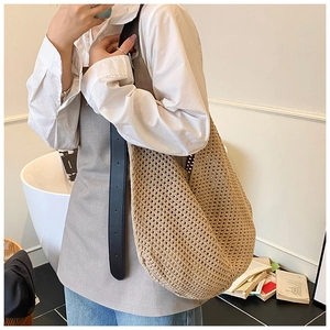 Detail of the oversized beige woven tote bag showing its intricate handmade crochet texture