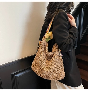 Dettaglio borsa tote in paglia intrecciata con motivi floreali e tracolla multicolore