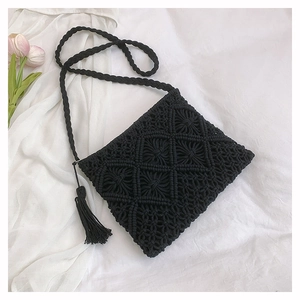 Detail of black woven cotton bag with tassels and geometric hollow patterns