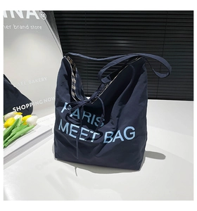 Detail view of large navy blue tote bag with Paris embroidery and patterned lining