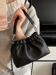Minimalist black pleated crossbody bag with pebble texture and silver chain strap